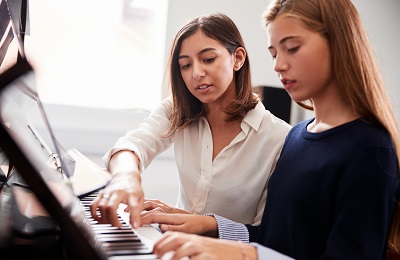 piano teacher and student
sitting at a piano